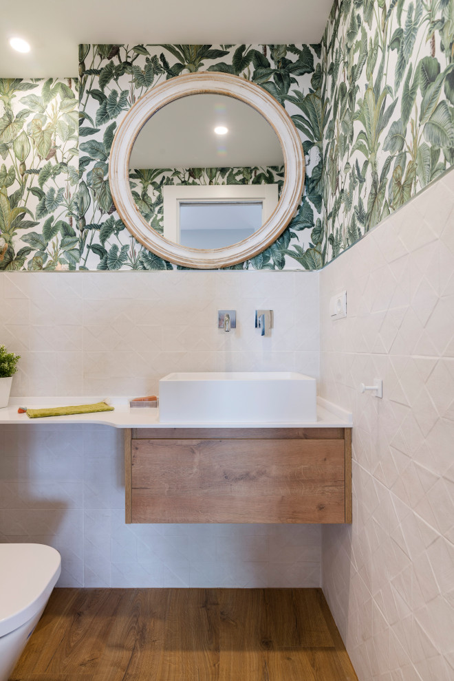 Стильный дизайн: маленький туалет в современном стиле с плоскими фасадами, белыми фасадами, инсталляцией, бежевой плиткой, керамической плиткой, зелеными стенами, полом из галечной плитки, настольной раковиной, коричневым полом, белой столешницей, встроенной тумбой и обоями на стенах для на участке и в саду - последний тренд