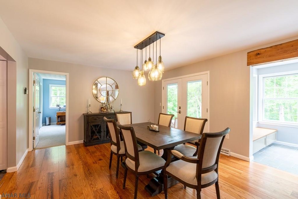 Mid-sized transitional dining room in Other with grey walls, medium hardwood floors and brown floor.