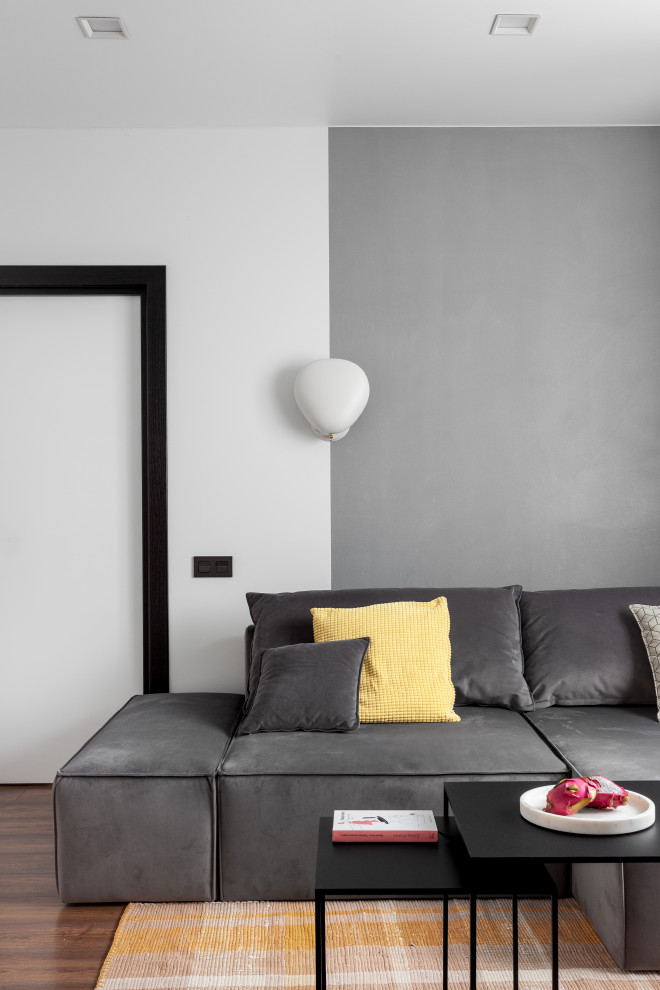 Пример оригинального дизайна: открытая, серо-белая гостиная комната среднего размера в стиле модернизм с желтыми стенами, темным паркетным полом, коричневым полом, обоями на стенах и ковром на полу без камина
