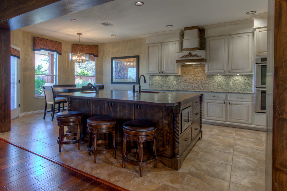 Example of a mid-sized mountain style l-shaped eat-in kitchen design in Austin with a single-bowl sink, wood countertops, stainless steel appliances and an island