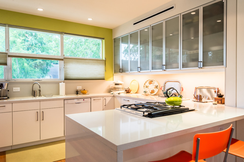 Example of a trendy u-shaped eat-in kitchen design in Houston with an undermount sink, glass-front cabinets, white cabinets, quartzite countertops, white appliances and green walls