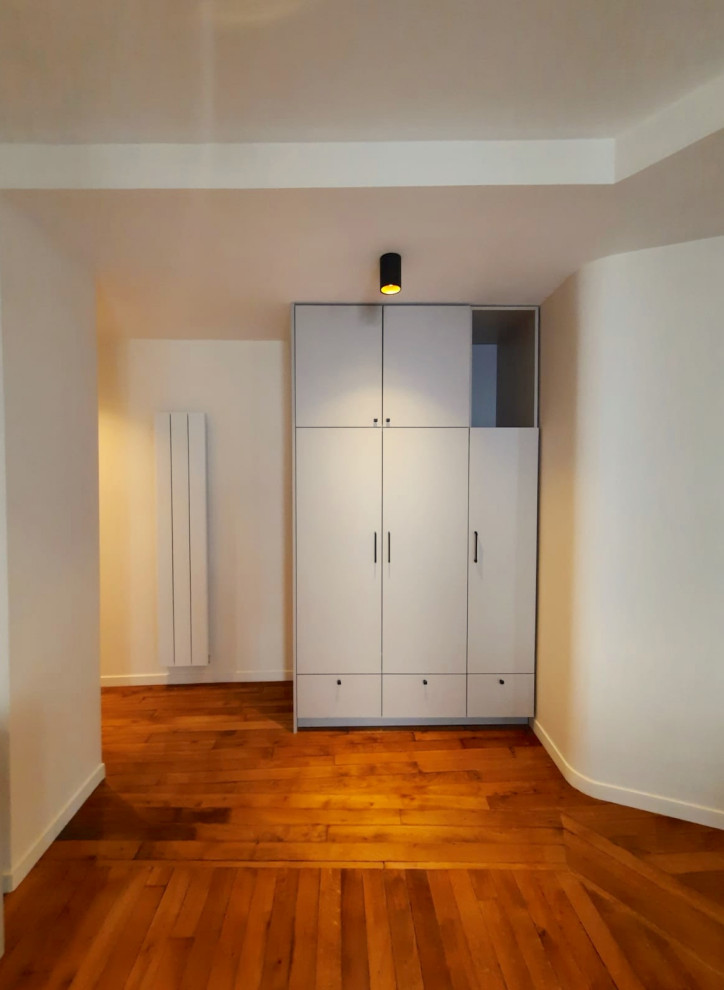 Idee per un armadio o armadio a muro unisex minimal con ante con bugna sagomata, ante beige e soffitto ribassato