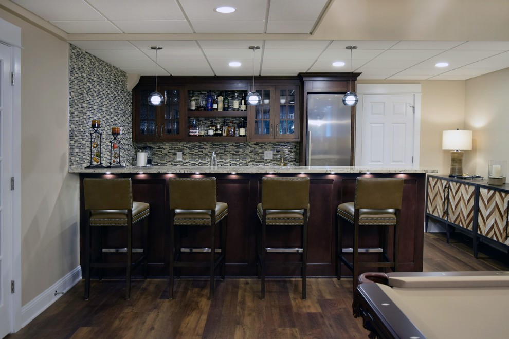 This is an example of a large traditional home bar in Philadelphia with laminate floors and brown floor.