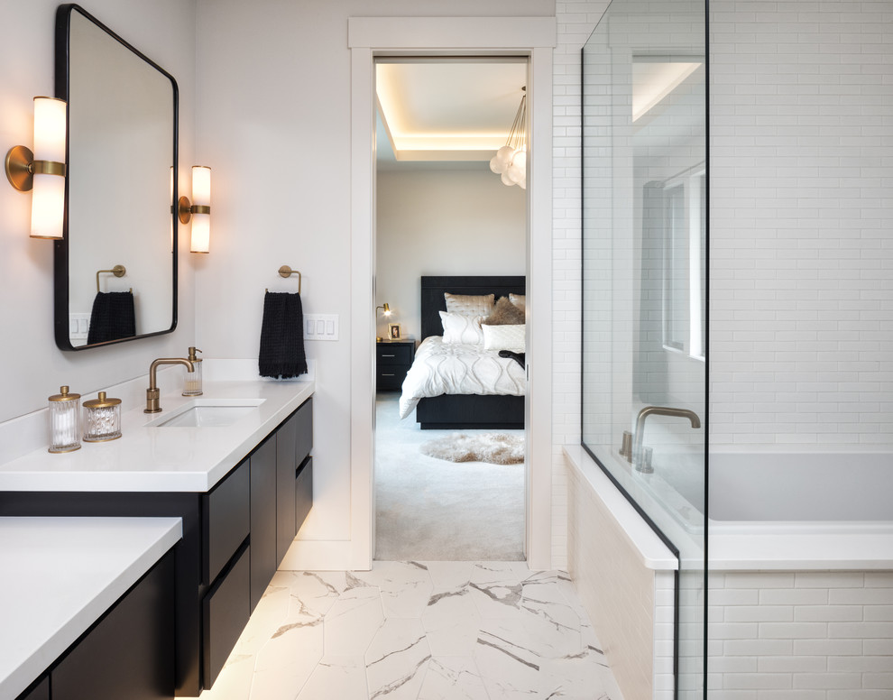 Inspiration for a large contemporary master bathroom in Minneapolis with flat-panel cabinets, black cabinets, an alcove tub, a shower/bathtub combo, a one-piece toilet, white tile, porcelain tile, white walls, porcelain floors, an undermount sink, engineered quartz benchtops, white floor, a hinged shower door and white benchtops.