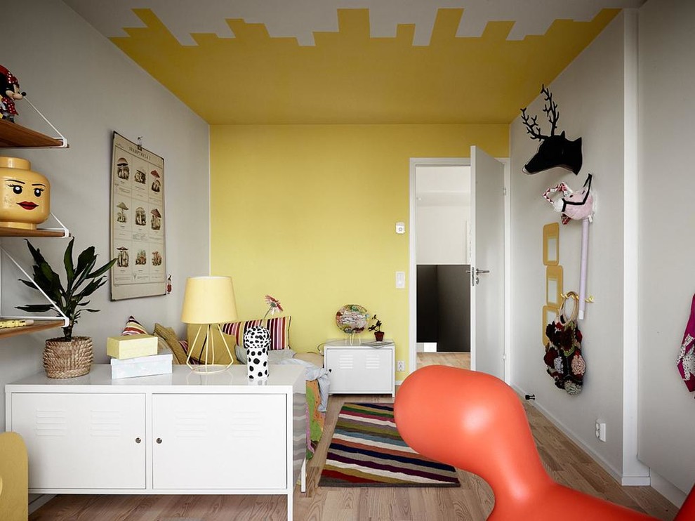 Inspiration for a mid-sized eclectic gender-neutral kids' bedroom for kids 4-10 years old in Stockholm with light hardwood floors and multi-coloured walls.