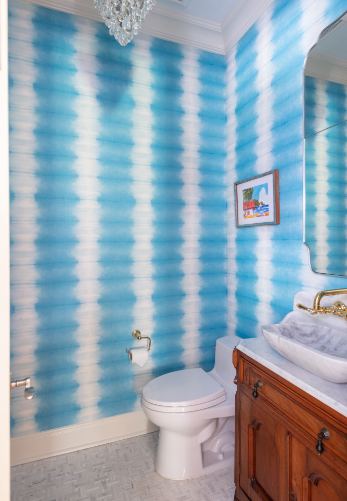 Bathroom - mid-sized transitional marble floor, gray floor, single-sink and wallpaper bathroom idea in Austin with medium tone wood cabinets, a one-piece toilet, a vessel sink, marble countertops, white countertops and a freestanding vanity