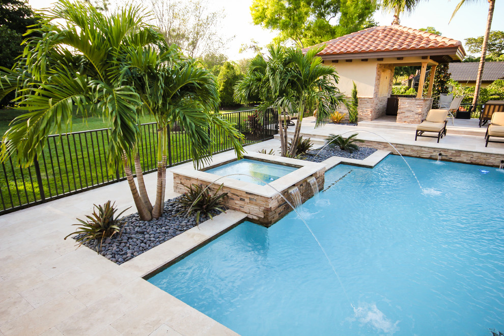 Design ideas for a mid-sized contemporary backyard rectangular natural pool in Miami with a hot tub and natural stone pavers.