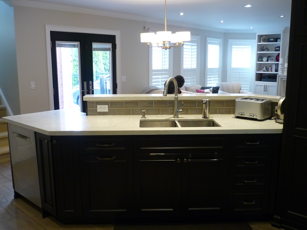 Inspiration for a mid-sized transitional l-shaped porcelain tile eat-in kitchen remodel in Toronto with an undermount sink, recessed-panel cabinets, porcelain backsplash, stainless steel appliances and a peninsula