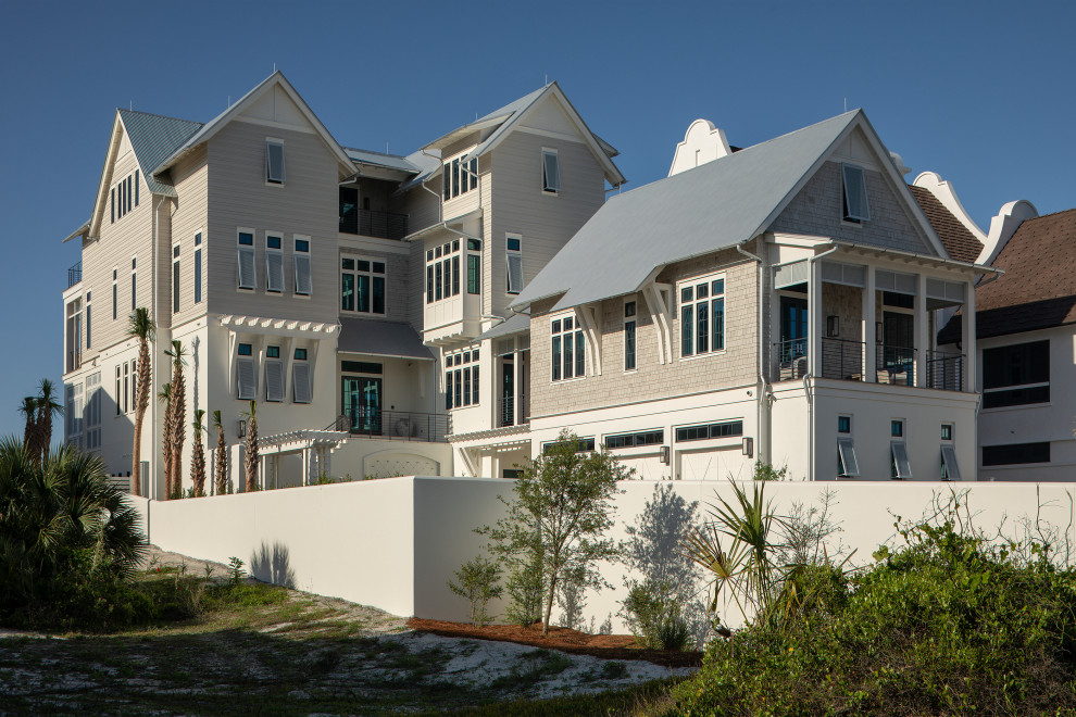 Idée de décoration pour une façade de maison grise marine en bardeaux à trois étages et plus avec un revêtement mixte, un toit à deux pans, un toit en métal et un toit gris.