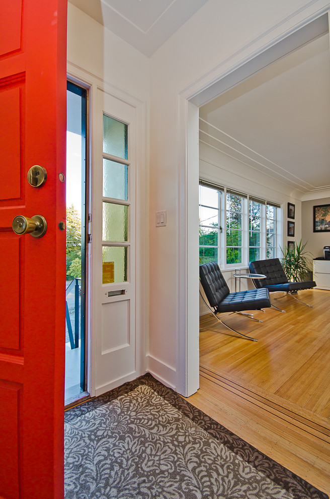 Inspiration for a small modern entryway in Vancouver with yellow walls, light hardwood floors and a single front door.
