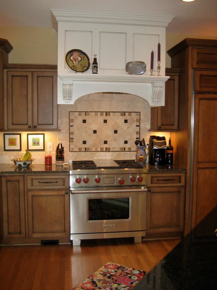 Inspiration for a mid-sized transitional l-shaped dark wood floor open concept kitchen remodel in Milwaukee with a double-bowl sink, recessed-panel cabinets, dark wood cabinets, beige backsplash, stone tile backsplash, stainless steel appliances, an island and granite countertops