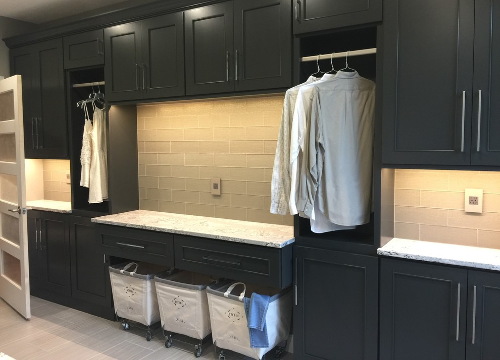 Design ideas for a large l-shaped dedicated laundry room in Chicago with an undermount sink, flat-panel cabinets, quartz benchtops, grey walls, ceramic floors, a side-by-side washer and dryer and black cabinets.
