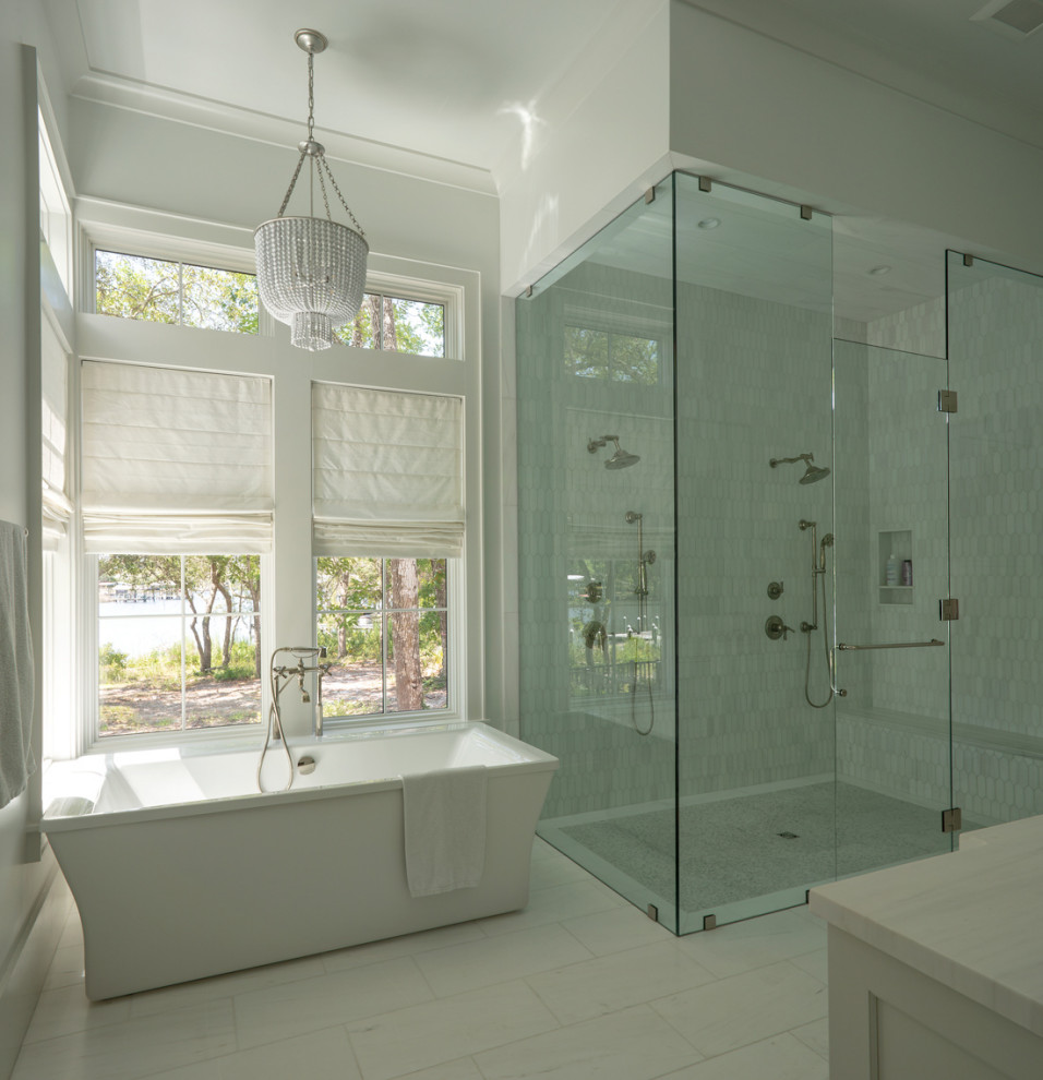 Photo of a large transitional master bathroom in Other with recessed-panel cabinets, white cabinets, a freestanding tub, a curbless shower, a one-piece toilet, white walls, ceramic floors, a drop-in sink, marble benchtops, white floor, a hinged shower door, white benchtops, an enclosed toilet, a double vanity and a built-in vanity.