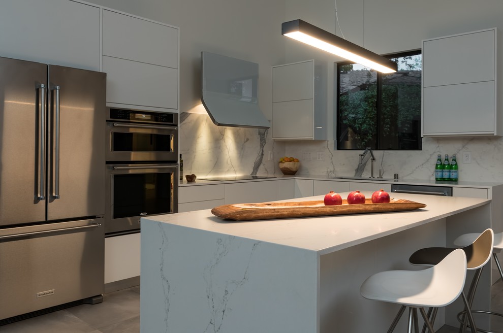 Inspiration for a large contemporary l-shaped open plan kitchen in Other with an undermount sink, flat-panel cabinets, white cabinets, quartz benchtops, stone slab splashback, stainless steel appliances, concrete floors, with island and grey floor.