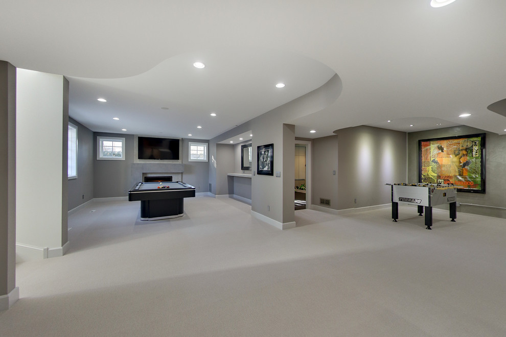 This is an example of a mid-sized contemporary fully buried basement in Minneapolis with grey walls, carpet, a standard fireplace and a concrete fireplace surround.