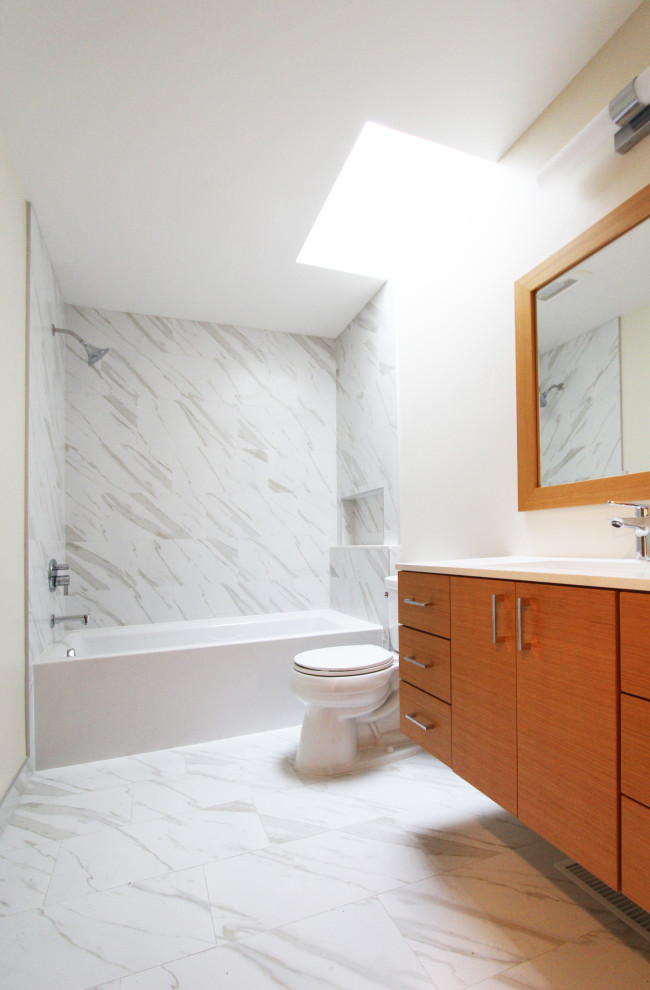 Alcove bathtub - mid-sized transitional 3/4 black and white tile and porcelain tile porcelain tile, white floor and single-sink alcove bathtub idea with flat-panel cabinets, light wood cabinets, a two-piece toilet, white walls, an undermount sink, quartz countertops, white countertops, a niche and a floating vanity
