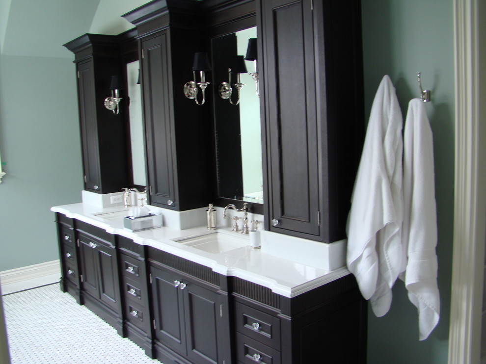Inspiration for a mid-sized traditional 3/4 bathroom in Toronto with recessed-panel cabinets, dark wood cabinets, a freestanding tub, a corner shower, blue walls, vinyl floors, an undermount sink and solid surface benchtops.