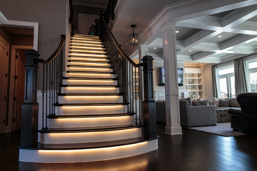 Large transitional wood straight staircase in Chicago with painted wood risers.