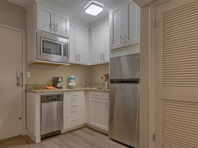 Inspiration for a small coastal l-shaped porcelain tile eat-in kitchen remodel with an undermount sink, shaker cabinets, white cabinets, granite countertops and no island