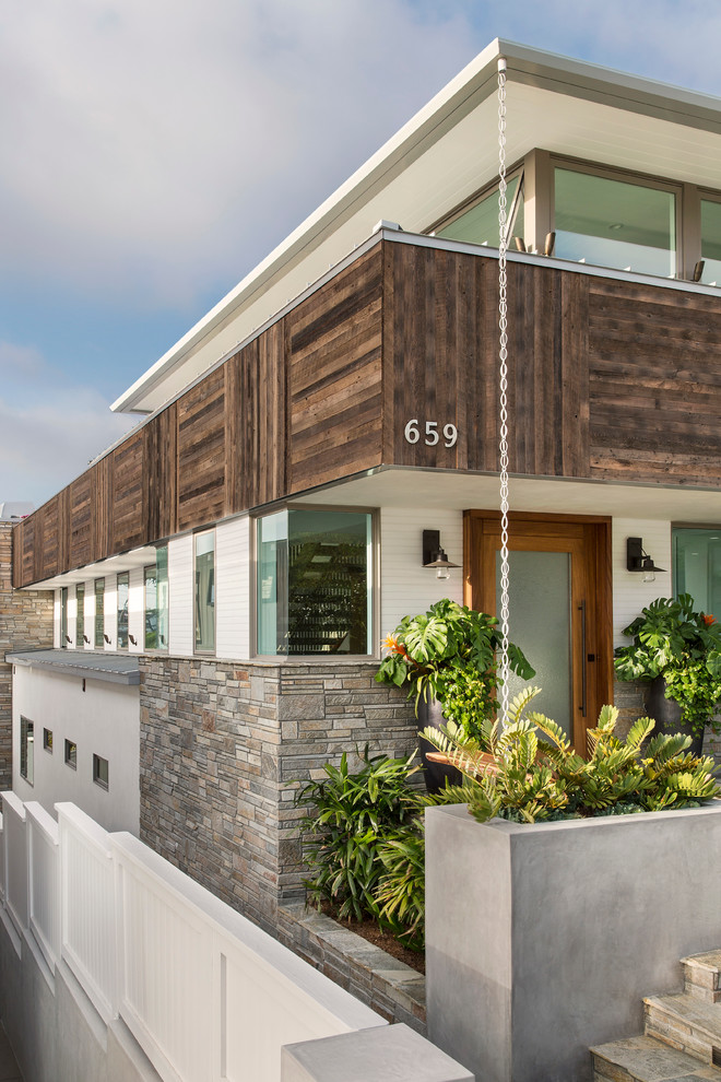 This is an example of a large contemporary three-storey white exterior in Los Angeles with wood siding.