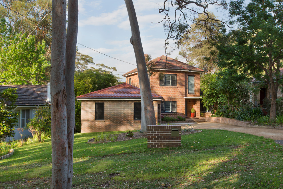 Photo of a large contemporary two-storey brick red house exterior in Sydney with a hip roof and a tile roof.