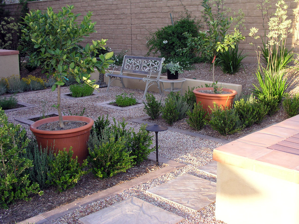This is an example of a mid-sized traditional backyard partial sun xeriscape in Los Angeles with gravel and a container garden.