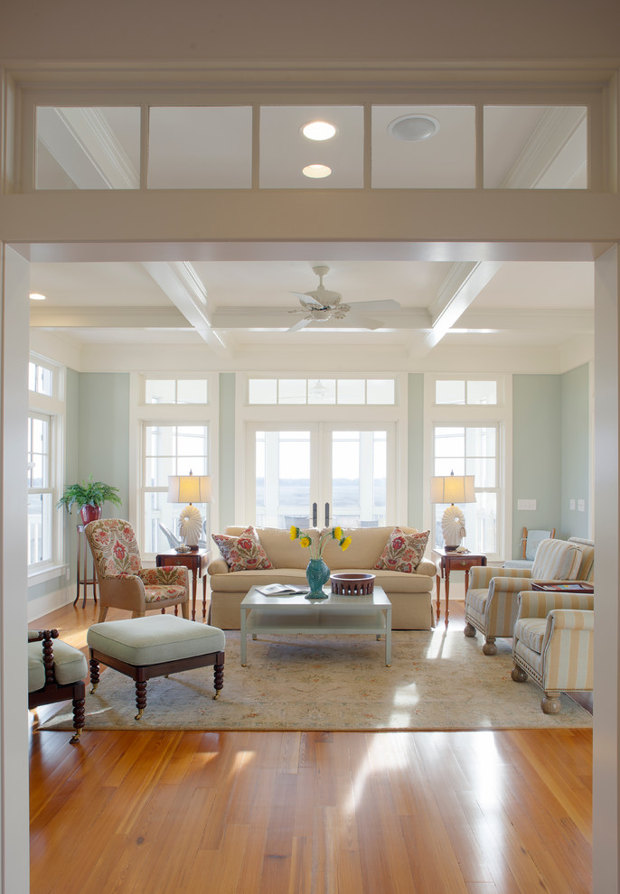 Photo of a large beach style formal open concept living room in Charleston with blue walls, medium hardwood floors, no tv and coffered.