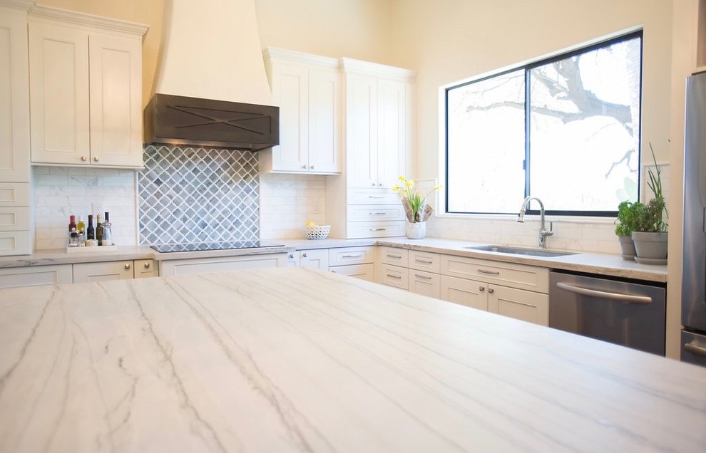 Large transitional l-shaped medium tone wood floor open concept kitchen photo in Phoenix with an undermount sink, shaker cabinets, white cabinets, quartzite countertops, marble backsplash, stainless steel appliances and an island