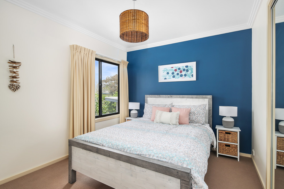 Inspiration for a mid-sized beach style guest bedroom in Melbourne with blue walls, carpet, no fireplace and brown floor.