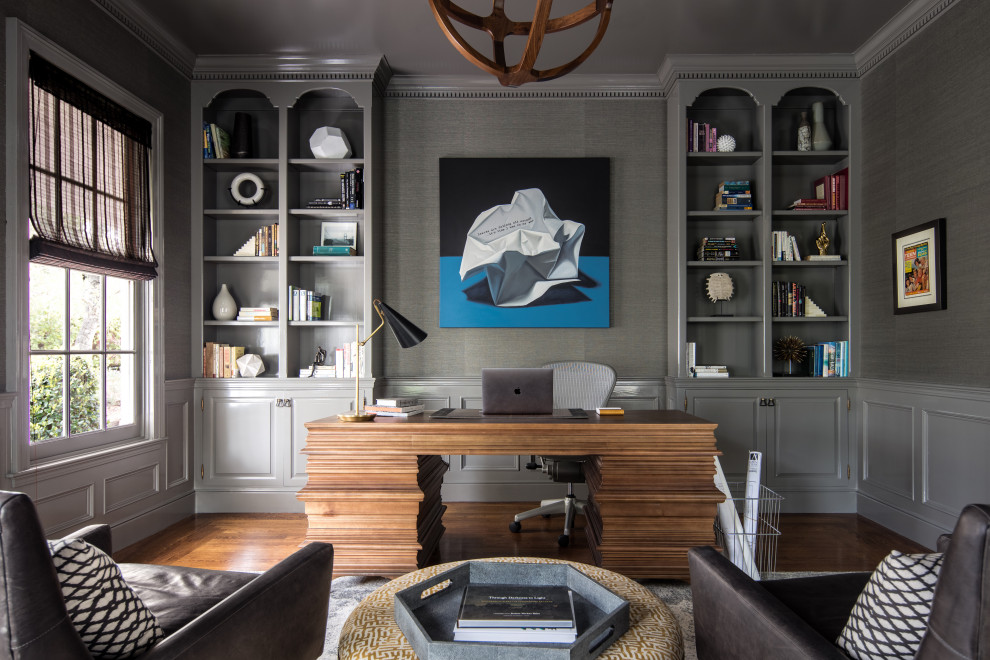 Imagen de despacho clásico renovado grande con paredes grises, suelo de madera oscura y escritorio independiente