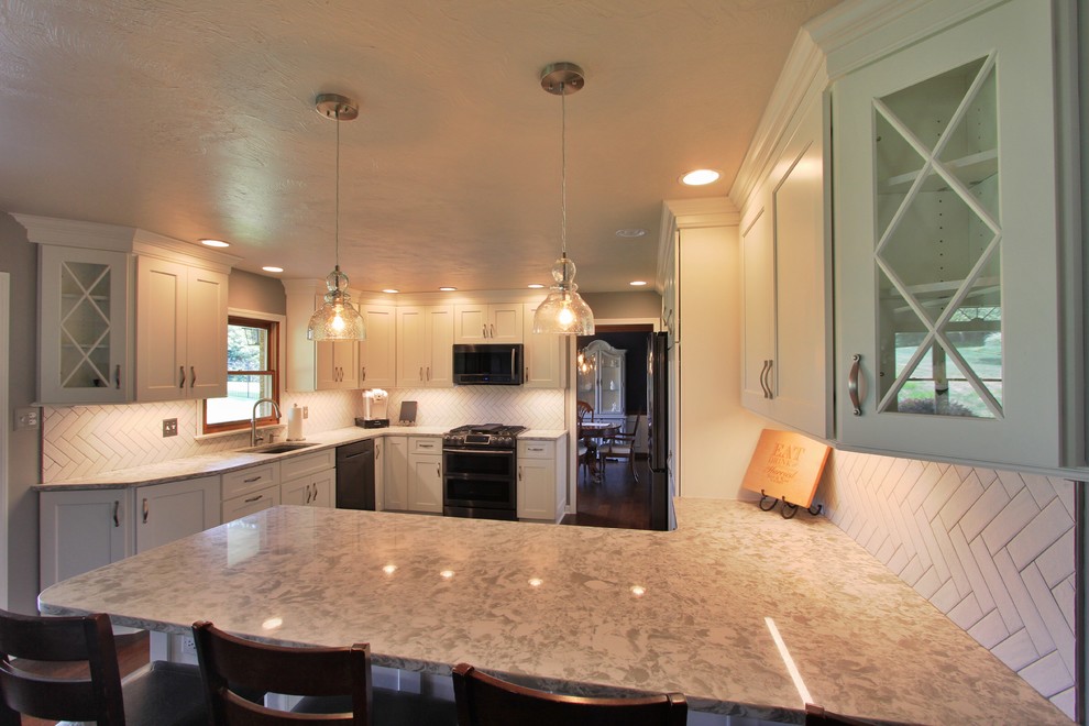Mid-sized l-shaped dark wood floor eat-in kitchen photo with an undermount sink, white cabinets, quartzite countertops, white backsplash, ceramic backsplash, black appliances and no island