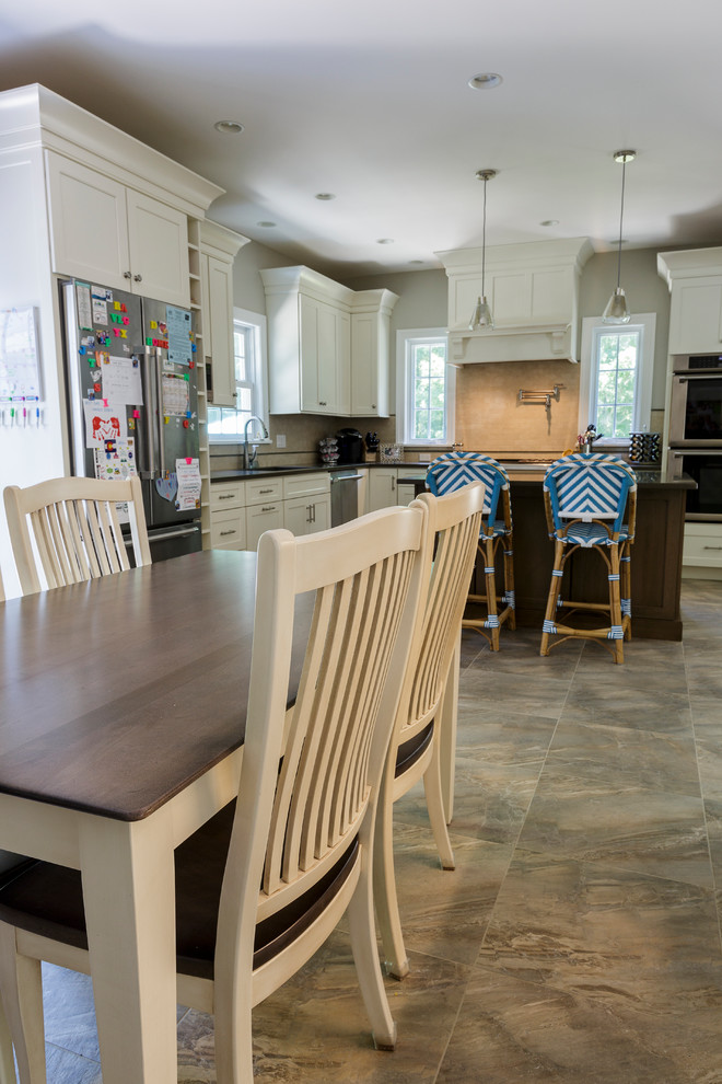 Example of a mid-sized mountain style l-shaped porcelain tile and beige floor open concept kitchen design in Bridgeport with an undermount sink, shaker cabinets, white cabinets, granite countertops, beige backsplash, porcelain backsplash, stainless steel appliances and an island
