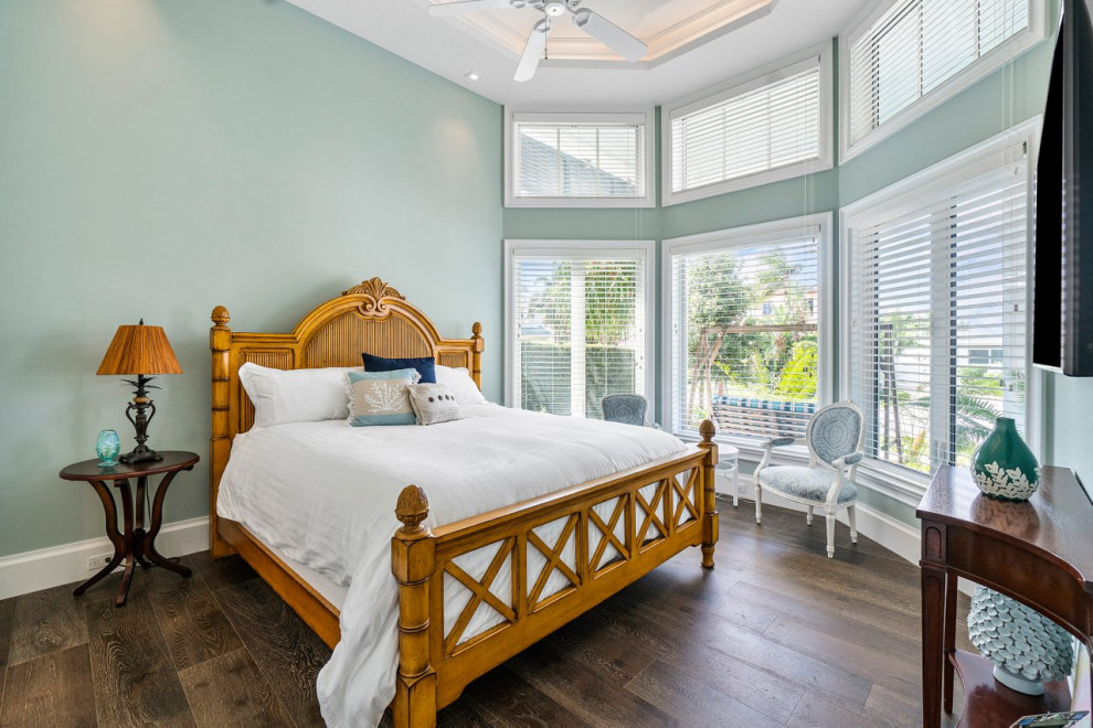 マイアミにある広いビーチスタイルのおしゃれな客用寝室 (緑の壁、無垢フローリング、茶色い床、三角天井) のレイアウト