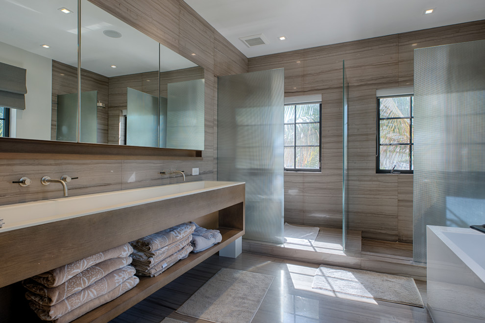 This is an example of a large contemporary master bathroom in Miami with a trough sink, open cabinets, dark wood cabinets, brown tile, a freestanding tub, an open shower and brown walls.