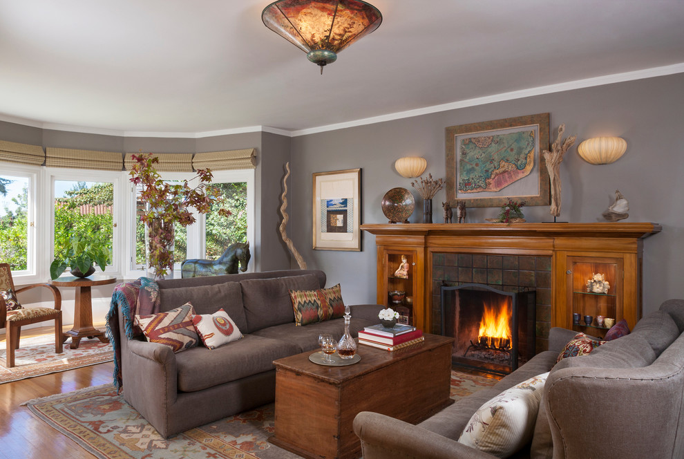 This is an example of an eclectic living room in San Francisco with grey walls, a tile fireplace surround and no tv.