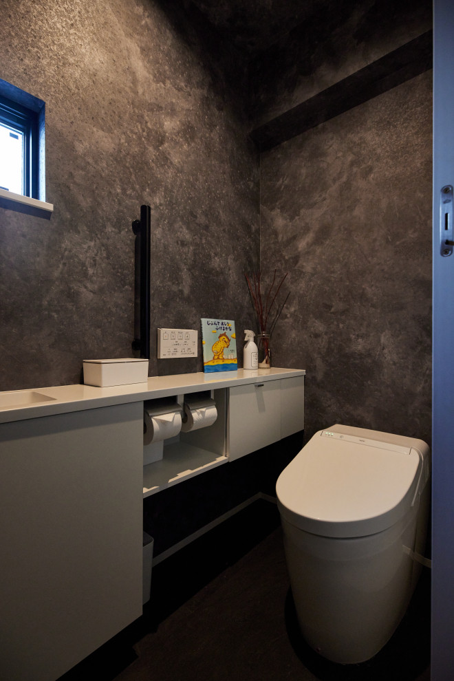 Idées déco pour un WC et toilettes moderne de taille moyenne avec WC à poser, un mur noir, un sol en vinyl, un plan de toilette en surface solide, un sol noir, un plan de toilette blanc, un plafond en papier peint et du papier peint.