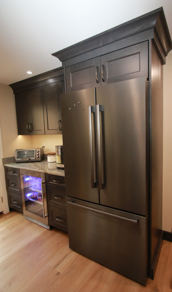 Inspiration for a mid-sized transitional u-shaped laminate floor and brown floor eat-in kitchen remodel in Boston with an undermount sink, shaker cabinets, brown cabinets, quartz countertops, black appliances, an island and multicolored countertops