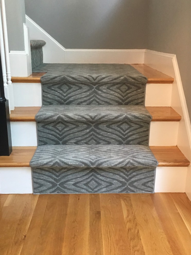 This is an example of a mid-sized modern carpeted l-shaped staircase in Boston with carpet risers.