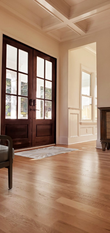 Design ideas for a foyer in Miami with light hardwood floors, a double front door, a brown front door and coffered.