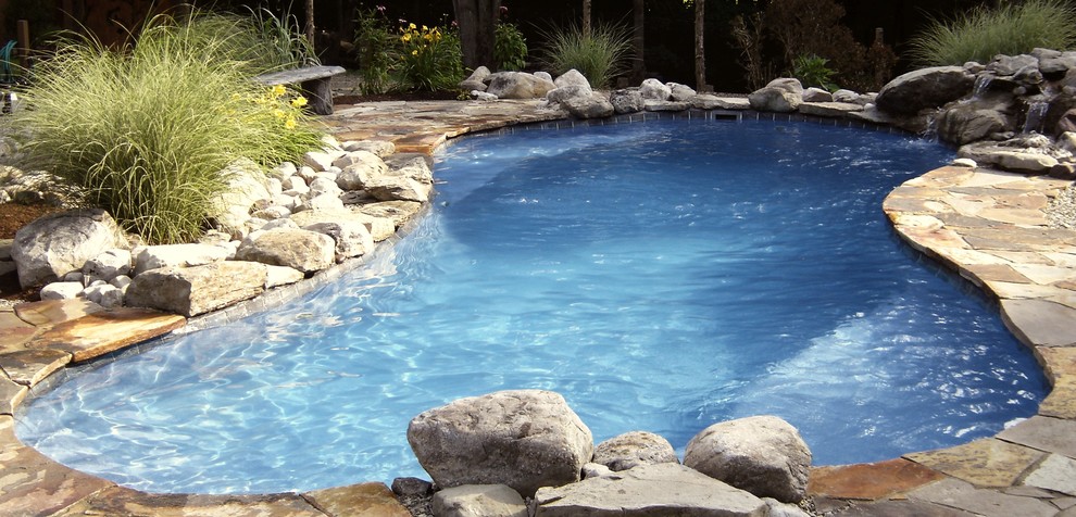 Inspiration for a large transitional backyard stamped concrete and custom-shaped aboveground pool remodel in New York