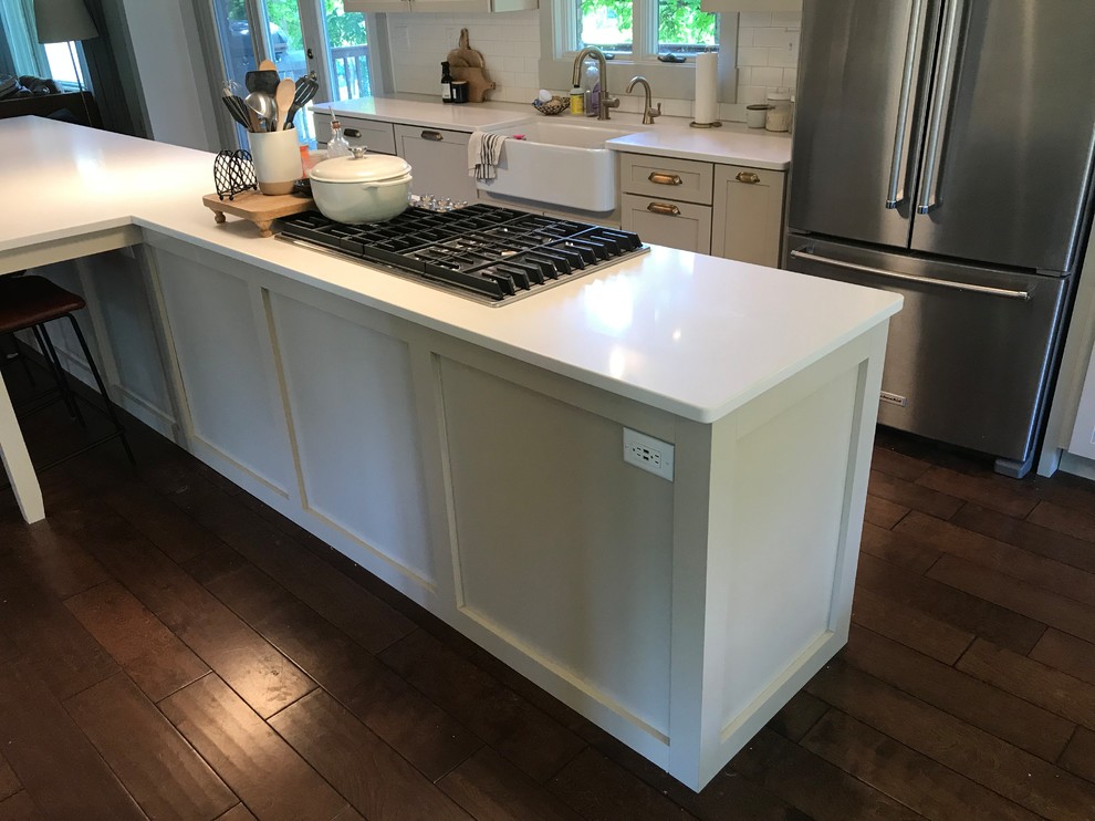 Inspiration for a large transitional galley dark wood floor and brown floor eat-in kitchen remodel in Chicago with a farmhouse sink, shaker cabinets, beige cabinets, quartz countertops, white backsplash, subway tile backsplash, stainless steel appliances, an island and white countertops