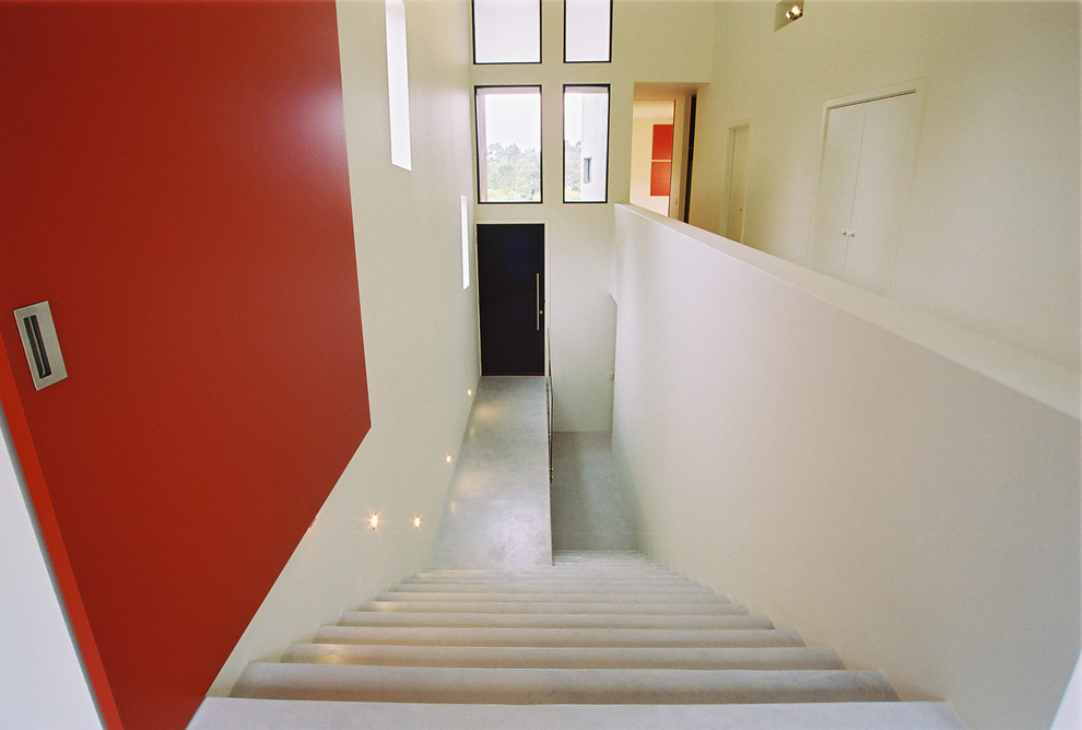 Photo of a mid-sized contemporary concrete straight staircase in Other with concrete risers.