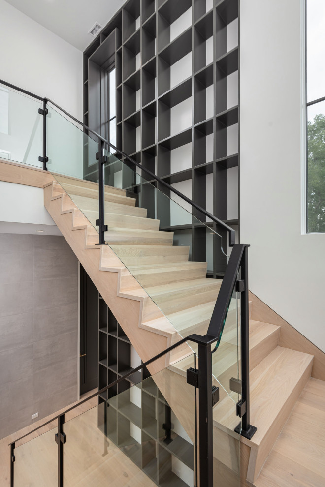 Photo of a large modern wood l-shaped staircase in Charleston with wood risers, metal railing and wood walls.