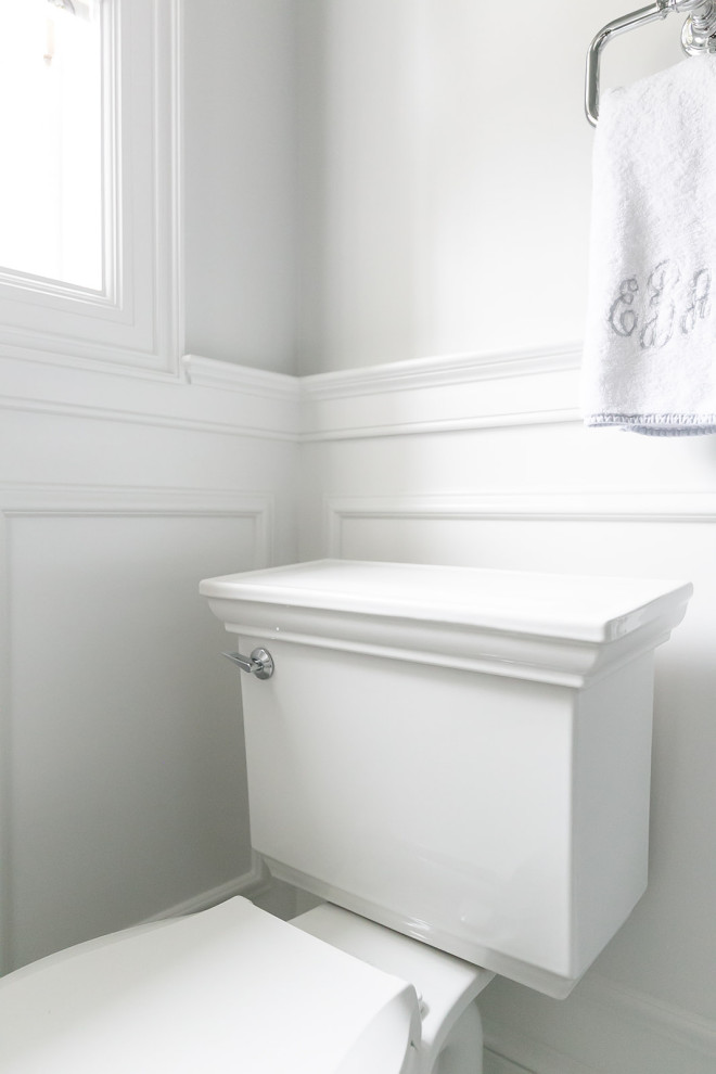 На фото: ванная комната в классическом стиле с белыми фасадами, открытым душем, раздельным унитазом, белой плиткой, мраморной плиткой, белыми стенами, мраморным полом, раковиной с пьедесталом, мраморной столешницей, белым полом, душем с распашными дверями, белой столешницей, нишей, тумбой под две раковины и панелями на стенах с