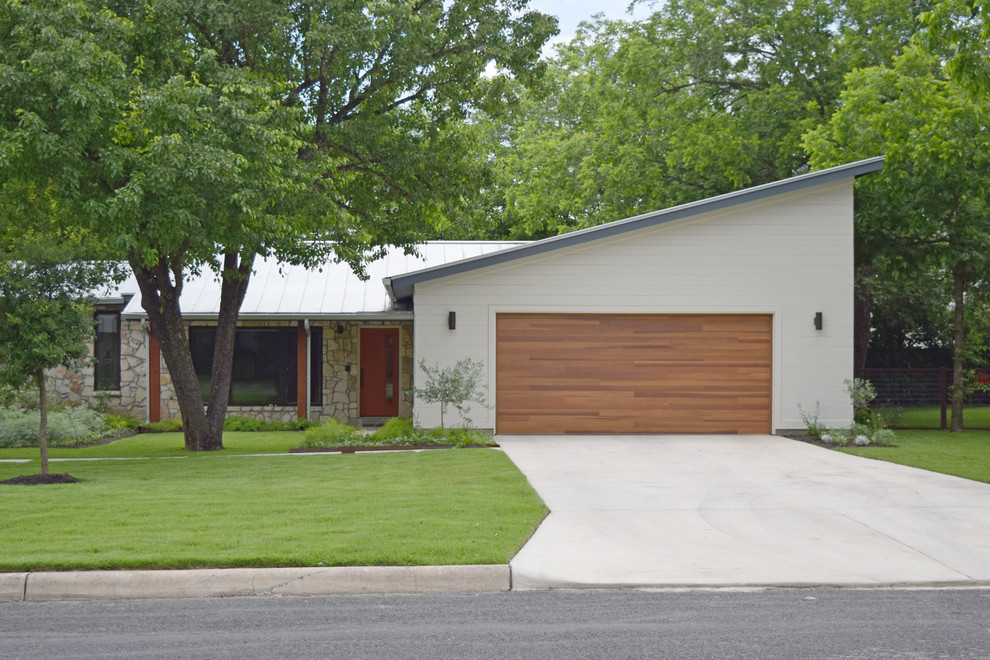 Photo of a mid-sized contemporary one-storey white house exterior in Austin with mixed siding, a shed roof and a metal roof.
