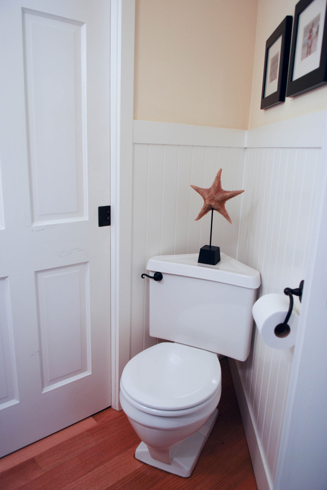 Small country powder room in San Francisco with open cabinets, medium wood cabinets, a two-piece toilet, yellow walls, medium hardwood floors, a vessel sink and wood benchtops.