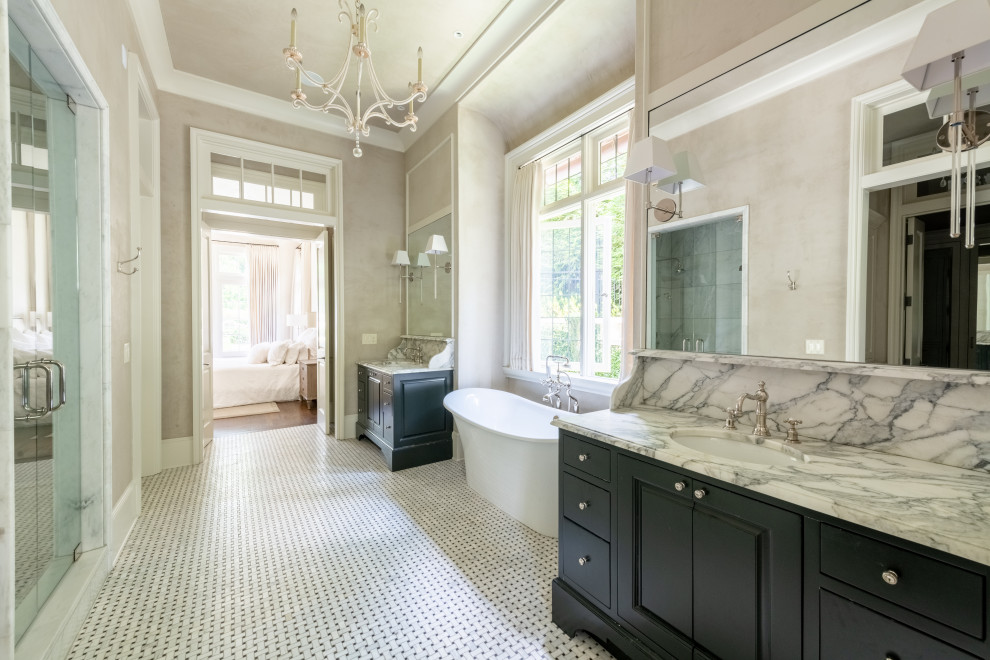 This is an example of a large traditional master bathroom in Atlanta with raised-panel cabinets, black cabinets, a freestanding tub, beige walls, an undermount sink, marble benchtops, white benchtops, a double vanity and a built-in vanity.