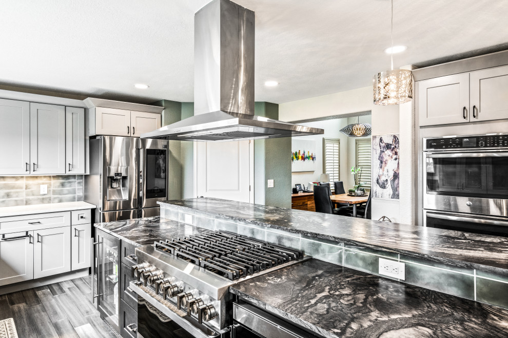 Exempel på ett stort klassiskt flerfärgad flerfärgat kök, med en undermonterad diskho, skåp i shakerstil, grå skåp, granitbänkskiva, grönt stänkskydd, stänkskydd i keramik, rostfria vitvaror, bambugolv, en köksö och brunt golv