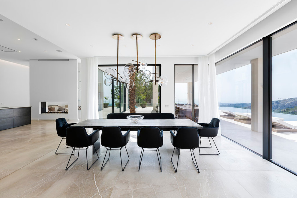 Photo of a large contemporary open plan dining in Palma de Mallorca with white walls and a two-sided fireplace.