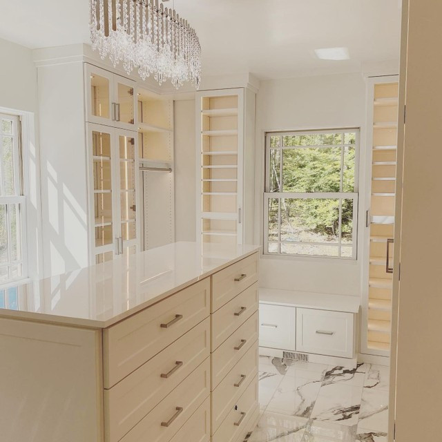 Imagen de armario vestidor unisex minimalista con armarios estilo shaker, puertas de armario blancas, suelo de mármol y suelo blanco